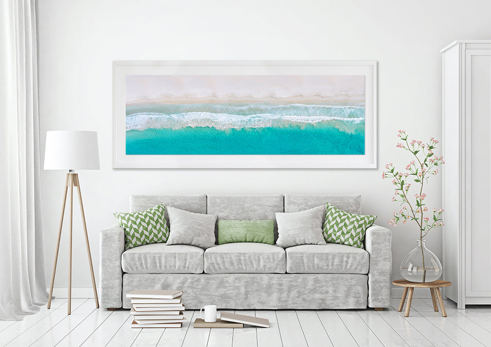 A aerial print of bunker bay hanging on wall above a sofa lounge
