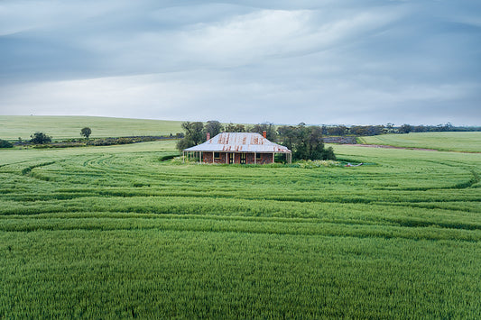 Australian farmhouse in the middle of a green paddock