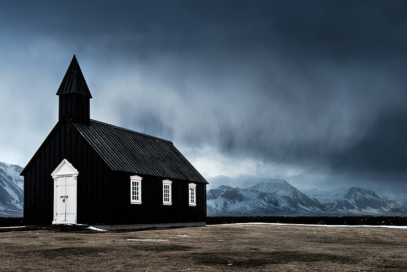Black church in Iceland with mountain backdrop